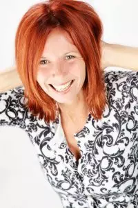 A woman with red hair smiling for the camera.