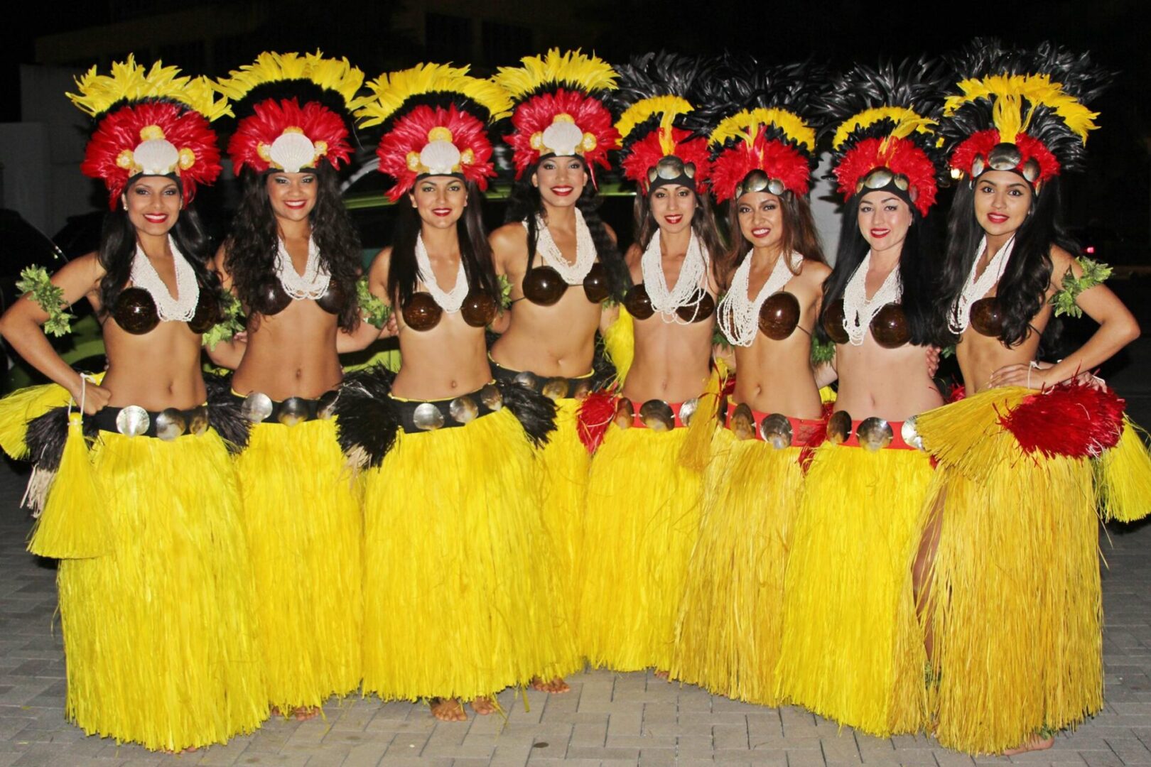 A group of women in hula skirts and headdresses.